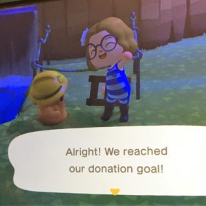 Screenshot of Animal Crossing player's avatar celebrating with solicitor Lloid that the fundraising goal has been reached. Text reads, "Alright! We reached our donation goal!"